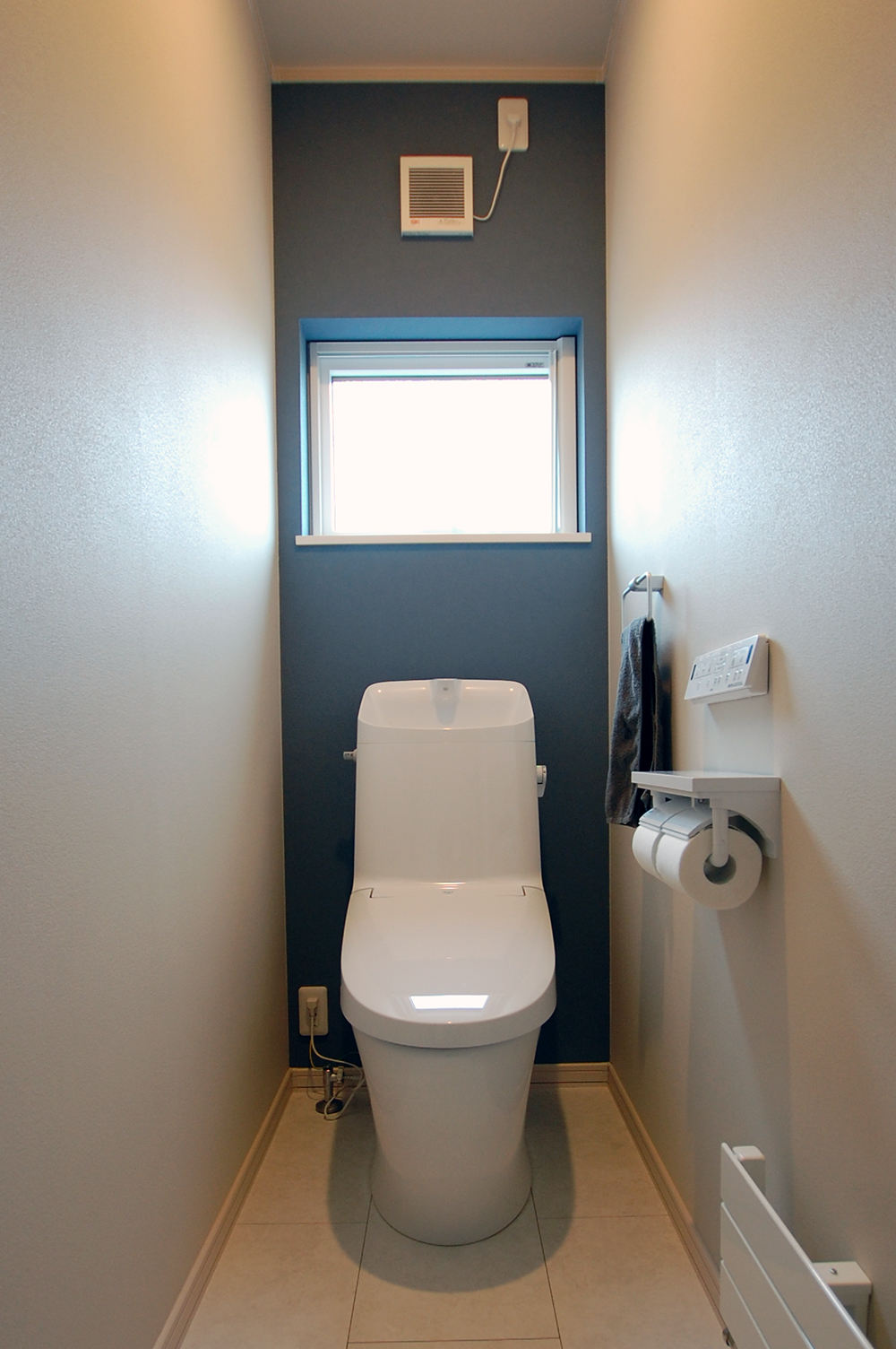 ネイビーのアクセントクロスを貼ったトイレの写真