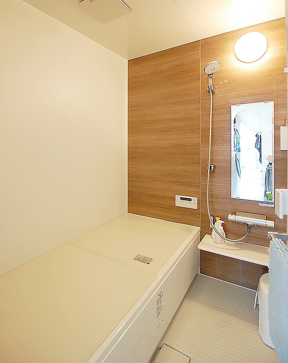 木目調のパネルと白いパネルのコントラストが優しい雰囲気のバスルーム。