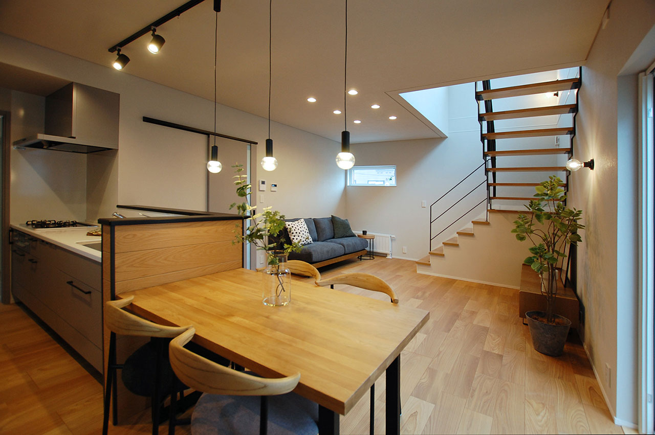 ダイニング側から見た26坪3LDKモデルハウスのリビングと階段。LDK全体がつながり、家族の気配を感じられる室内空間。