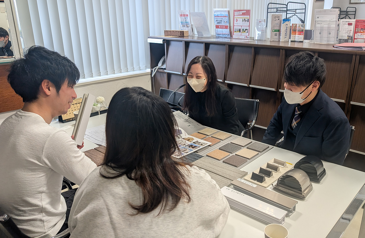 札幌のイワクラホームにてお客様と外壁材の打合せをするスタッフ平野と設計担当・森下
